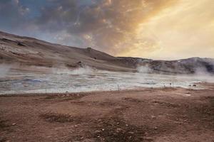 Blick auf den Dampf, der während des Sonnenuntergangs aus dem Krater im geothermischen Gebiet von Hverir austritt foto