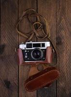Vintage alte Kamera auf rustikalem Holzhintergrund. Ansicht von oben foto
