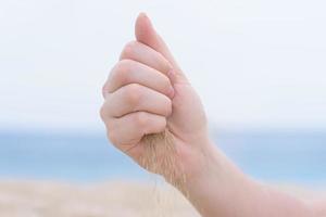 Hand mit Sand am Strand foto