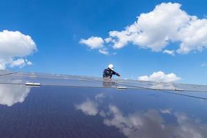 der Solarpark mit dem Techniker entfernt die Mutter, um das beschädigte Solarpanel zu ersetzen, alternative Energie, um die Energie der Welt zu sparen, Photovoltaik-Modul-Idee für saubere Energieerzeugung foto