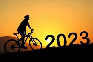 Mountainbiker-Silhouette und frohes neues Jahr 2023 foto