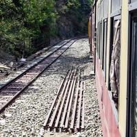 Spielzeugeisenbahn, die sich auf Berghängen bewegt, schöne Aussicht, ein Seitenberg, ein Seitental, das sich auf der Eisenbahn zum Hügel bewegt, inmitten grüner Naturwälder. Spielzeugeisenbahn von Kalka nach Shimla in Indien foto