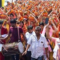 neu delhi, indien 03. april 2022 - frauen mit kalash auf dem kopf während des jagannath-tempels mangal kalash yatra, indische hindu-anhänger tragen irdene töpfe mit heiligem wasser mit einer kokosnuss darauf foto