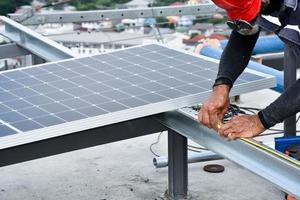 Der Techniker bohrt Löcher, um die Solarzelle mit einer elektrischen Bohrmaschine auf dem Dach zu montieren. foto