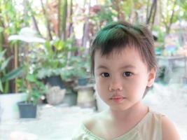 3 Jahre altes süßes asiatisches Mädchen, kleines Kleinkind mit entzückenden kurzen Haaren, die in die Kamera schauen foto