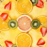 geschnittene Früchte Hintergrund. Erdbeere, Kiwi, Ananas, Grapefruit, Orange foto