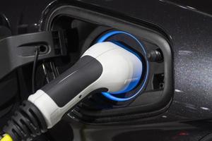 das aufladen der batterie für das auto neue automobile innovationen das an ein elektroauto angeschlossene netzteil wird aufgeladen foto