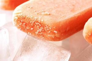 Frucht Eis am Stiel auf Eis mit Erdbeere, Orange, Ananas, Mango foto