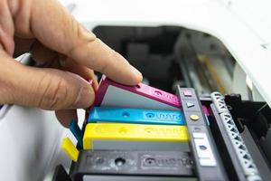 Techniker installieren die Tintenpatrone eines Tintenstrahldruckers das Gerät des Büroautomaten zum Drucken foto