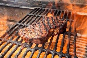 New York Steak auf Grill mit Feuer foto