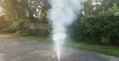 Beleuchtetes buntes Feuerwerk auf asphaltierter Auffahrt mit Rauch foto