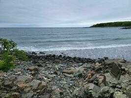 Felsen am felsigen Ufer von Maine mit Meerwasser foto