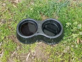 schwarze Hundewasserschüssel aus Kunststoff auf grünem Gras foto