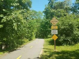 asphaltierter Radweg mit steilen Hügeln und Warnschildern foto