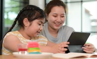 asiatische Mädchen lernen mit einem Tutor, Privatunterricht zu Hause, Schwestern und Schwestern. foto