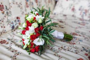 Blumenstrauß aus roten und weißen Rosen auf dem Sofa foto