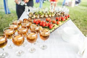 dekorierter schöner tisch mit kerzen bei der feier. Hochzeit. Geburtstag. romantisches Abendessen im Garten. Jubiläum. schöne Glaswaren. Sonnenlicht. foto