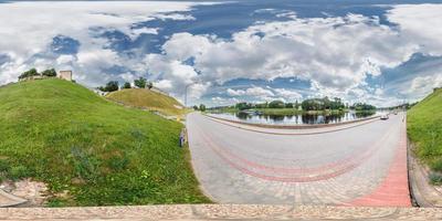 volles 360-Grad-Panorama in gleichrechteckiger Kugelprojektion alte mittelalterliche Burgruine auf dem Berg in der Nähe des modernen Flussufers, vr-Inhalt foto