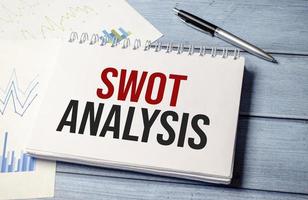 Stift und ein weißes Blatt Papier mit der Text-Swot-Analyse foto