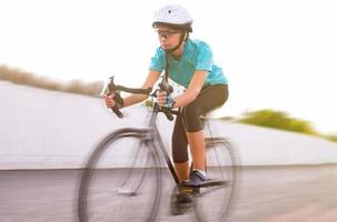 junge Sportlerin, die auf einem Fahrrad läuft. bewegungsunscharfes Bild