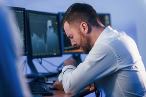 fühle mich schlecht, versagen. aktienhändler, der im büro mit börsentechnologie arbeitet foto