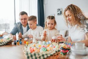 am Tisch sitzen. glückliche familie, die zusammen osterferien feiert foto