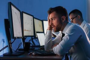 Konzept des Scheiterns. Zwei Aktienhändler, die im Büro mit Börsentechnologie arbeiten foto