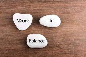 Work-Life-Balance-Wort der weißen Steine auf hölzernem Hintergrund foto