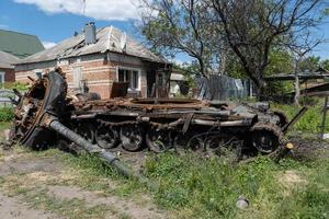 charkiw, ukraine - 04. mai 2022. ein verbrannter russischer panzer in der nähe eines wohngebäudes. krieg in der ukraine 2022. russische raketen in der landschaft von charkiw ukraine. Russische Aggression. russischer angriff auf die ukraine. foto