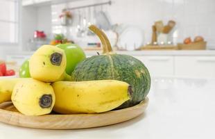 Schließen Sie herauf Früchte auf hölzerner Platte im weißen sauberen Küchentisch. selektiver Fokus. foto