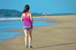 Frau läuft am Strand foto