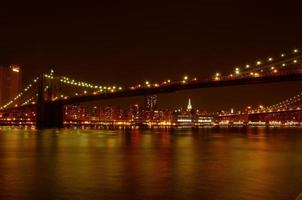 Brooklyn Bridge und Manhattan Waterfront in der Nacht foto
