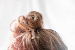 Messy Bun auf dem Kopf einer blonden Frau. leicht lockiges Haar. foto