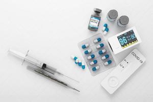 covid-19 selbsttestkit mit impfstoff und medikament auf weißem hintergrund. 3D-Rendering foto