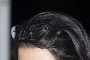 Brille - auf den Kopf eines Mädchens gewickelt - in der edlen Nachtruhe - mit einem Schatten, der durch die Brille reflektiert wird - kurzzeitig. foto