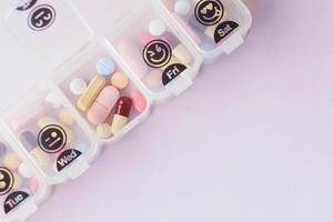 Nahaufnahme von medizinischen Pillen in einer Pillendose auf dem Tisch foto