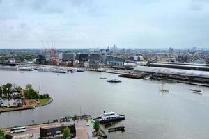 amsterdam, die niederlande - 28. april 2019 stadtansicht zum zentralen teil der stadt, fähre und kanal von oben an bewölktem typisch holländischem tag. foto