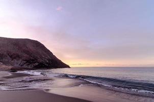 Strand und Welle bei Sonnenaufgang foto