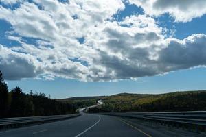 Landschaft mit Blick auf eine kurvenreiche Straße unter dem Himmel mit Wolken foto