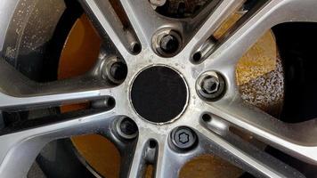 das originale Leichtmetallrad, schmutzig und zerkratzt auf der Autonahaufnahme. Abgenutzte Autoräder warten auf Reparatur. selektiver Fokus. Autoreparatur- und Restaurierungskonzept erforderlich. beschädigtes Autorad. foto