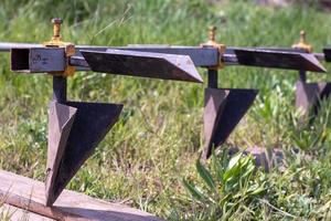 landwirtschaftlicher manueller Metallpflug auf dem Feld. Pflügen des Landes vor der Aussaat. Nahansicht. Inventar zum Pflügen von Kartoffeln auf dem Land. Ein Pflug ist ein Werkzeug zum Pflügen von dichtem Boden und zum Anheben von jungfräulichem Boden. foto