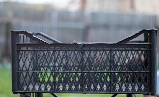 leere schwarze plastikboxen, die für pflanzen oder ernte zusammengestapelt sind. an einem sonnigen Tag im Frühjahr. Gartenkonzept. Sammel- und Aufbewahrungsboxen für Haushaltsfrüchte, die im Hinterhof stehen. foto