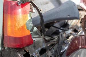 eine rot-orangefarbene zerbrochene Glaslampe an einem Auto infolge eines heftigen Zusammenstoßes. Nahaufnahme des kaputten Rückscheinwerfers aufgrund eines Autounfalls oder unachtsamen Fahrens. Versicherungsfall, Fahrsicherheitskonzept. foto