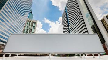 leere weiße Werbetafel mit modernen City-Business-Center-Gebäuden im Hintergrund mit blauem Himmel. foto