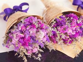 Nahaufnahme von violetten und bunten kleinen Blumen, die in drei Blumensträußen angeordnet sind. foto