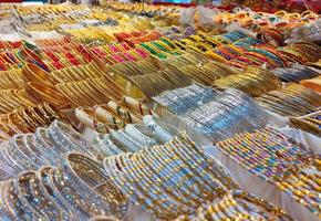 Bunte Armreifen aus einem Geschäft in Bangladesch, Hintergrund aus bunten Armreifen, die mit Glitzer und einfarbigen Armreifen gestapelt sind, leuchtende bunte Armreifen foto