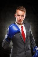 Geschäftsmann in blauen Boxhandschuhen mit Haltung posieren. foto