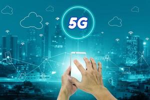 5g-Netzwerkschnittstelle und Symbolkonzept, Hand, die ein Smartphone mit Stadtbild hält foto