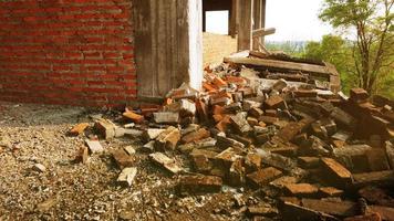 Nahaufnahme der Trümmer eines Industriegebäudes, die in einen Haufen Beton und Ziegel einstürzen. und die gezackten Trümmer, die durch das Versagen der Ingenieure bei der verlassenen Konstruktion verursacht wurden. foto