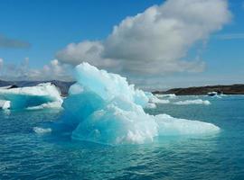 leuchtend blauer Eisberg, der im blauen kalten Wasser des Jokulsarlon-Sees in Island schwimmt 36 foto